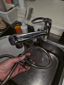 新しいジャバラホースを手に持ち、水栓への接続位置を確認